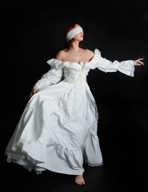 Kapalı portre güzel bayan model antika beyaz hayalet gelin gelinliği giyiyor peçeli bir maske takıyor. Karanlık stüdyo arka planında izole bir figür, el hareketi