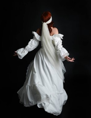 Tam boy portre güzel kadın manken antika beyaz hayalet gelin gelinliği, peçeli maske takan yüz. Karanlık stüdyo arka planında izole edilmiş yürüyen figür,