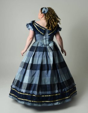 Viktorya Dönemi 'nden kalma klasik Mavi Balo Elbisesi, artı boyut modeli, tam boy Arka Görünüm pozu giymiş Viktorya dönemi kadını uzaklaşıyor. Stüdyo arkaplanındaki izole kişi.