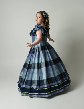 Viktorya Dönemi 'nden kalma klasik Mavi Balo Elbisesi, artı boyut modeli, tam boy Arka Görünüm pozu giymiş Viktorya dönemi kadını uzaklaşıyor. Stüdyo arkaplanındaki izole kişi.