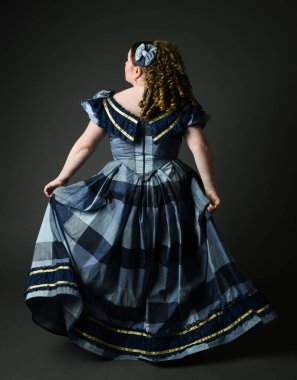 Viktorya dönemi kadınının tarihi klasik mavi balo elbisesi içinde tam boy portresi, güzel artı beden modeli. İzole edilmiş siluet figürü, uzaklaşıyor, arka plan, karanlık stüdyo arka plan..