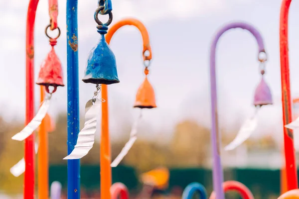 multi-colored wind chimes with metal plates that create a beautiful sound from the wind. selective focus.
