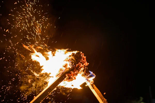 Karanlık bir arkaplanda yanan iki meşale, yanan meşalelerden çıkan duman ve ateş 2021.