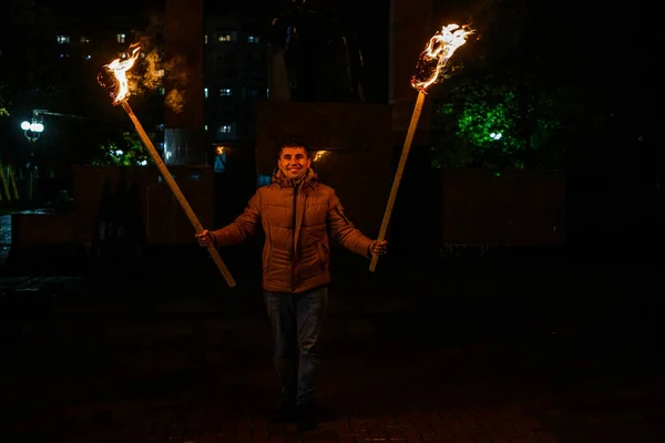 The man is holding two torches, a peaceful participant of the action, an evening with torches.2020