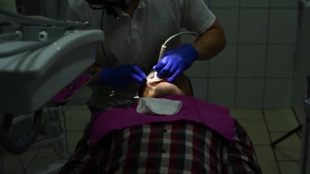 Ο οδοντίατρος χρησιμοποιεί υπερηχογράφημα για να αφαιρέσει ταρτάρ και σκληρή πλάκα στα δόντια. — Αρχείο Βίντεο