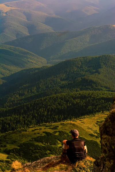 観光客は岩の上に座って、遠くを見ます,山の中でピップ・イワン・チョルノヒルスキー山の上の写真,風景や観光客の壮大な写真. — ストック写真