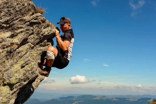 カルパチア山脈の登山、男は保護なしで岩のピークを登るだけで、アマチュア登山. — ストック写真