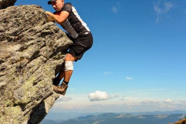 Karpatlar 'daki dağcılık, bir adam korumasız, yalnız, amatör dağcılık .2020' de kayalık bir tepeye tırmanır.