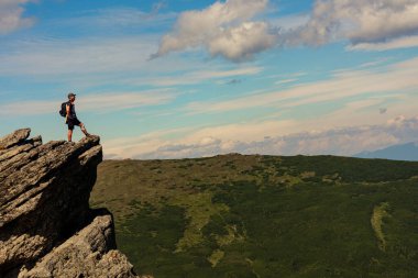 A man on one of the peaks of Carpathian beauties, Carpathian mountains, Montenegrin ridge, Eared Stone mountain.2020 clipart