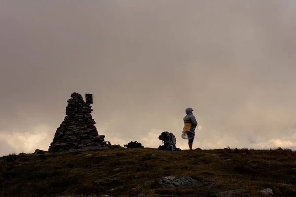 ブレベンスケル山の頂上に雲の中にいる観光客のカップル レインコートの上に立つ観光客 悲観的な天気 2020 — ストック写真
