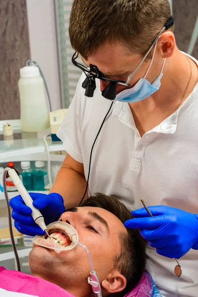 牙科诊所 私人诊所 牙医使用双筒望远镜取得最佳效果和工作效果 清除牙垢的过程 2020 — 图库照片