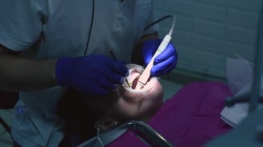 Diş hekimi ultrasonla hastaya ağız temizliği yapar..