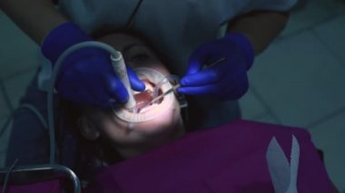 Dişçideki hasta, ultrasonla tartarı alıyor..