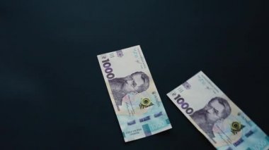 Banknotlar binlerce hryvnianın yüzey değeri, para uçar, siyah bir yüzeye düşer, yeni Hryvnia mezhepleri.