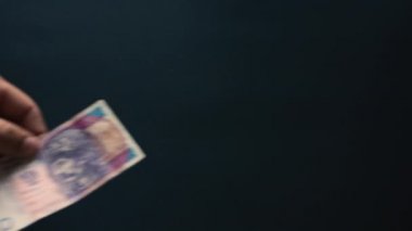 Ukrayna hrivnisi bin tane hryvniaya düşer, kara arka planda uçar, Ukrayna devleti parası, bir sürü fatura..