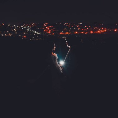 Ivano-Frankivsk, Ukrayna 13 Ağustos 2019: Şehir gece lambalarının arka planında iki gelin. 2020