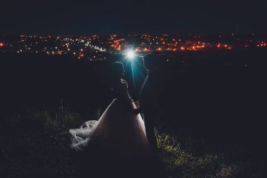 Ivano-Frankivsk, Ukrayna 13 Ağustos 2019: Şehir gece lambalarının arka planında iki gelin. 2020