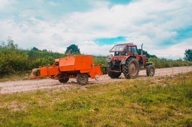 Sığırlar için saman toplama işlemi, tarlada balya yapan bir traktör, eski makineler. 2020