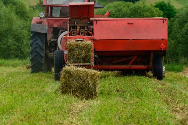 Tarlada eski kırmızı traktör, Ukrayna tarlaları ve eski makineler, tarlada saman hasadı. 2021