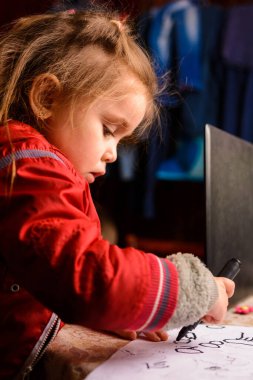 Anaokulu kızı daire çizmeyi öğreniyor, siyah halkalar beyaz bir sayfa üzerinde, mutlu çocuk 2020