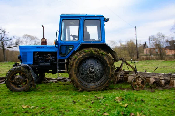 耕作土地 拖拉机犁地 一辆蓝色的小拖拉机和一辆有三个骑士的犁 2021年 — 图库照片