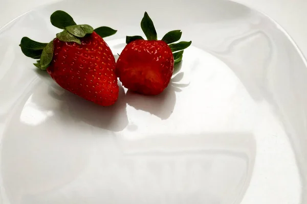 Deux Fraises Sur Une Assiette Une Fraise Mordue Gros Plan — Photo