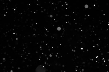Siyah arkaplandaki Bokeh beyaz kar. Kar yağışı - yeni tasarım ögesi.