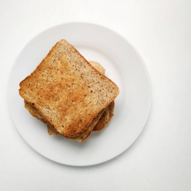 Kare gevrek ve mis kokulu tost beyaz tabakta, kahvaltıda tost. 2021.