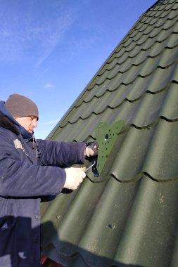 İşçi yükseklikte çalışır, galvanize çatıya kar kesme elementleri yerleştirir, soğuk mevsimde çalışır, işçiler sigortasız çalışır. 2020