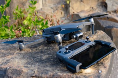 Quadcopter ve uzaktan kumanda taşa yakın, uçmak için fotoğraf ekipmanı. Yeni