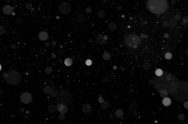 Siyah arkaplandaki Bokeh beyaz kar. Kar yağışı - yeni tasarım ögesi.