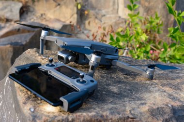 Quadcopter ve uzaktan kumanda taşa yakın, uçmak için fotoğraf ekipmanı. Yeni
