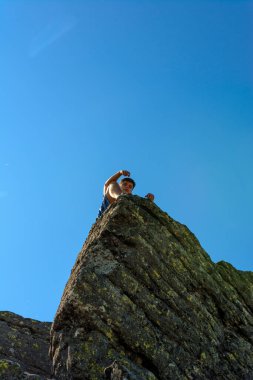 Büyük bir taş bloğun tepesindeki bir turist, Smotrych Dağı 'nın tepesi, Ukrayna Karpatlarının kayalık zirvelerinden biri. 2020