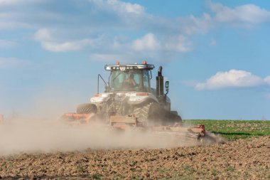 Dolyna, Ukrayna 29 Nisan 2020: tırtılların üzerindeki daha zorlu traktör ve tarım şirketi Khorytsia 'nın arazi ekimi ile birlikte. yeni
