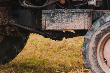 Eski kırmızı traktör tarlada saman yapma mevsiminde, balyalara saman bastırıyor, yiyecek topluyor. 2021