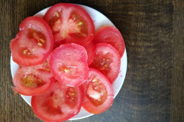 Beyaz tabakta dilimlenmiş domates, taze ve sağlıklı sebzeler, beslenme ve sağlıklı yiyecekler. Yeni