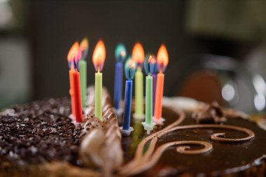 Bayram pastasında renkli mumlar yakmak, çocuğun onuncu yıldönümü. yeni