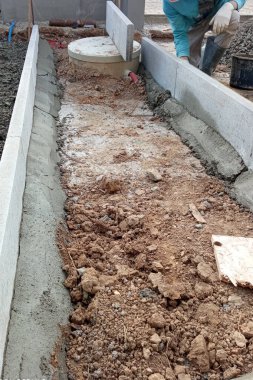 İşçiler evin etrafındaki suyu boşaltmak için drenaj çalışmaları yapıyorlar. Yeraltı suyu drenajı.