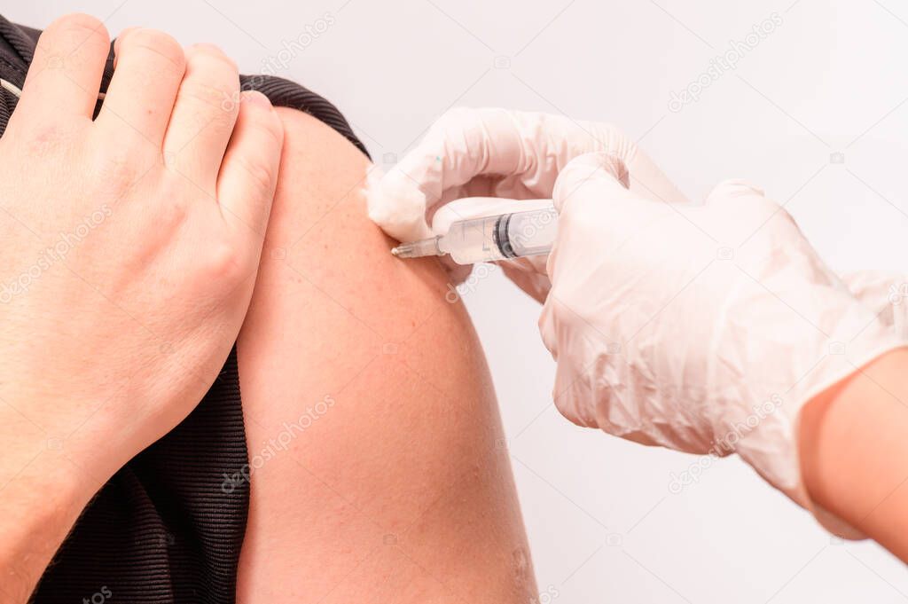 Vaccination close up, injection of vaccine in hand, doctor in white gloves. new