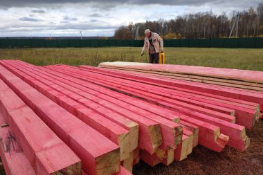 Kaluga, Rusya 15 Ekim 2019: İnşaat işi, bir işçi özel bir çözümle ahşap kirişleri boyar. yeni