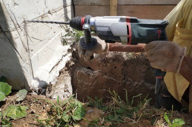 Beton duvarda kaya matkabıyla delik açmak, delgi operatörü.Yeni