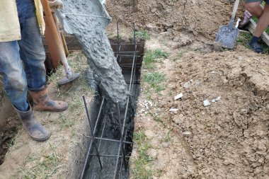 İnşaat katlarının ticari beton döşemesi sırasında beton dökülüyor, işçiler betonu düzleştiriyor. Yeni