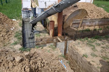 İnşaat katlarının ticari beton döşemesi sırasında beton dökülüyor, işçiler betonu düzleştiriyor. Yeni