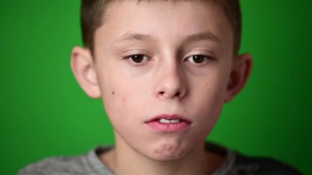 Der Junge auf grünem Hintergrund legt eine Platte zur Ausrichtung der vorderen oberen Zähne an, Ausrichtung der oberen Zähne. — Stockvideo
