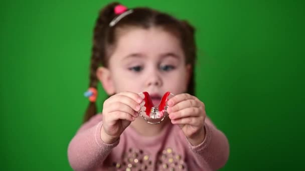 The child examines and demonstrates a dental plate to straighten crooked teeth. — Stock Video