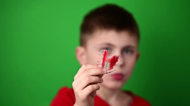 Девятилетний мальчик держит табличку зубного выравнивания, мерзость и демонстрацию зубного выравнивания. — стоковое видео