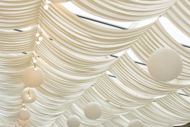 Tavanda balo şeklinde beyaz süslemeler ve avizeler, düğün süsleri. yeni