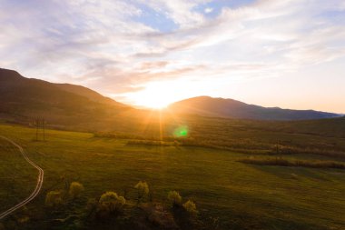 Karpat köyündeki alçak dağlar ve otlaklar, gün batımında manzara, Ukrayna Karpatları ve tarım alanları, dağlarda ve tarlalarda patikalar. yeni