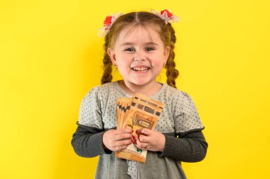 Sarı arka planda bir kızın portresi, elinde para tutan bir çocuk, büyük miktarda para, Avrupa Avrosu ve bir çocuk. yeni