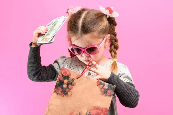 Menina Óculos Com Pacote Dinheiro Fundo Rosa Criança Compras Novo — Fotografia de Stock
